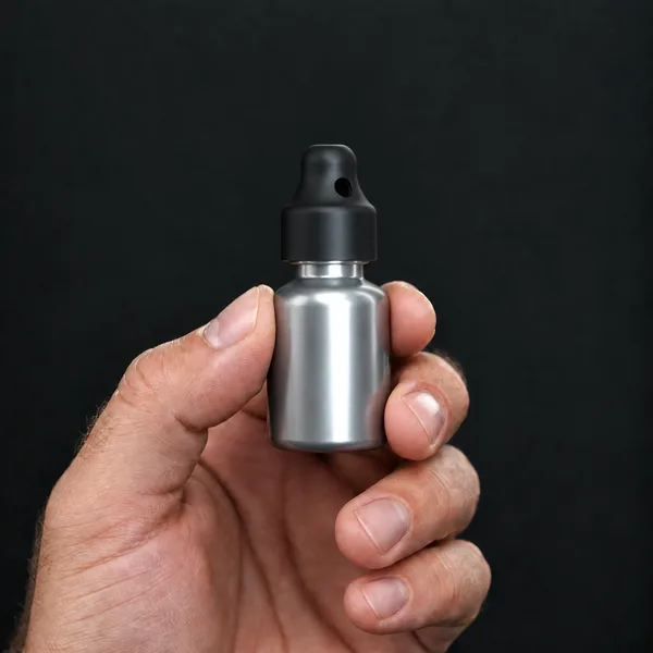 Hand holding a 10 ml aluminium bottle with a SN*F Small sniffer cap