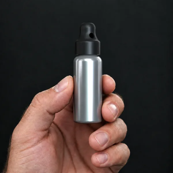 Hand holding a 24 ml aluminium bottle with a SN*F Small sniffer cap