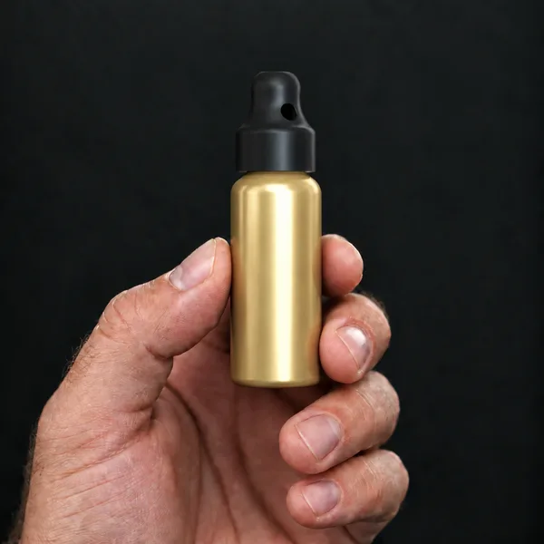 Hand holding a 24 ml aluminium, gold bottle with a SN*F Small sniffer cap