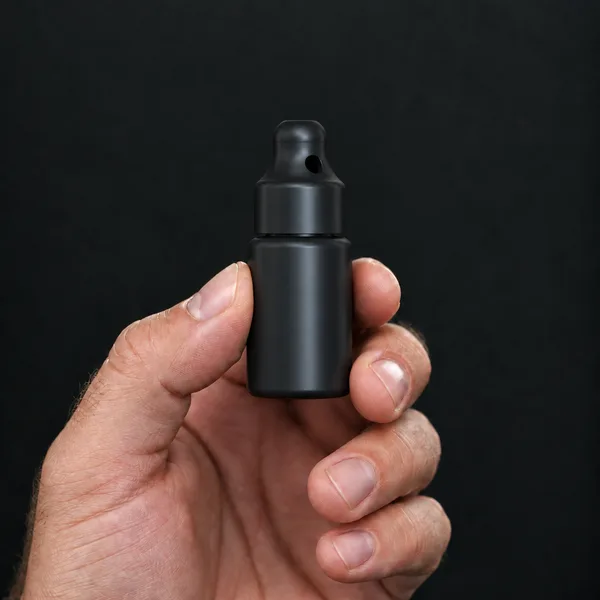 Hand holding a 10 ml black bottle with a SN*F Small sniffer cap